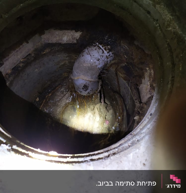 צינור מתכת חלוד בתוך בור בטון